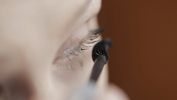 Young Woman Is Making Up Her Eyes Young Woman Is Making Up Her Eyes