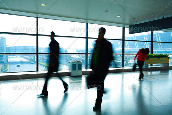 Passengers in a hurry to walk the modern airport interior corridors