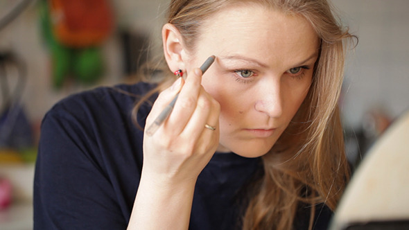Young Woman Shaping Her Eyebrows Young Woman Shaping Her Eyebrows