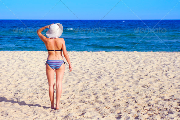 Woman on the beach with white hat