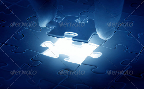 Hands placing last piece of a Puzzle