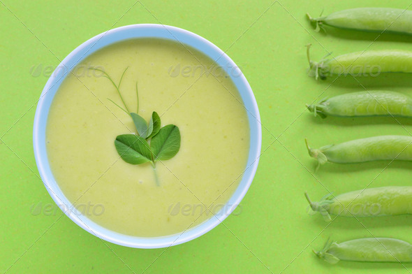 Cold creamy green pea soup and pea pod.