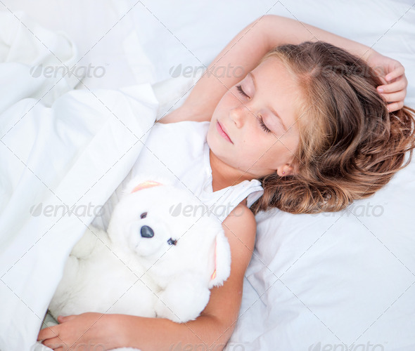 little girl in the bed with teddy bear