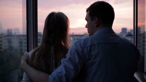 Young Couple on the Balcony at Sunset Young Couple on the Balcony at Sunset