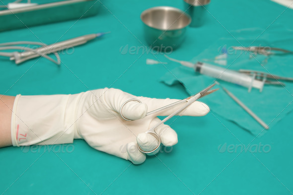 set of eye surgical instrument on sterile table with a hand of d