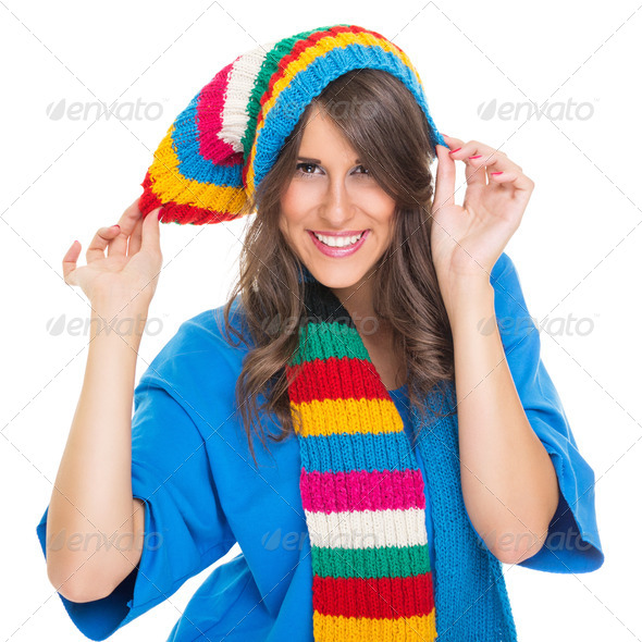 Cute young woman wearing colorful winter hat and scarf - Stock Photo - Images