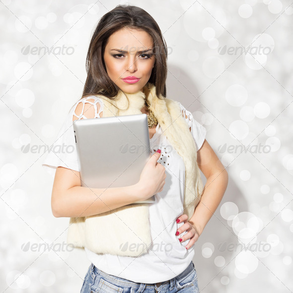 Fashionable young woman holding tablet wearing fur
