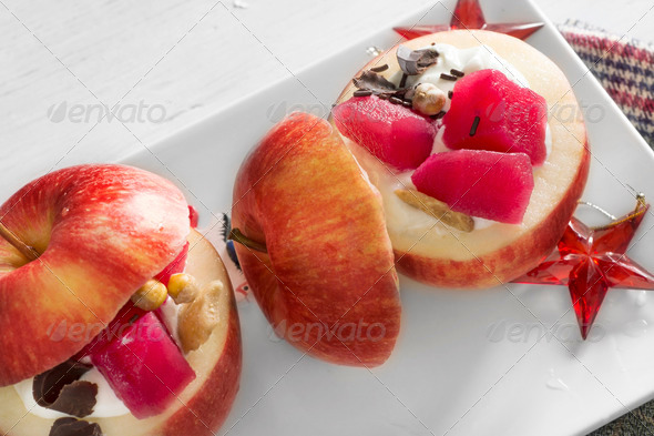 Apples stuffed with cream and fruit on white plate