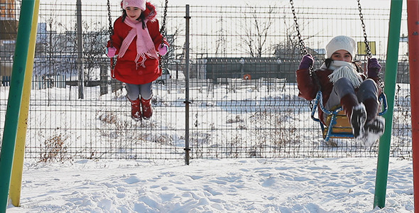 Girls in Swings in Winter Playground Girls in Swings in Winter Playground