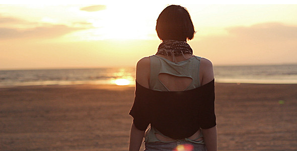 Girl is Walking on the Beach at Sunset Girl is Walking on the Beach at Sunset