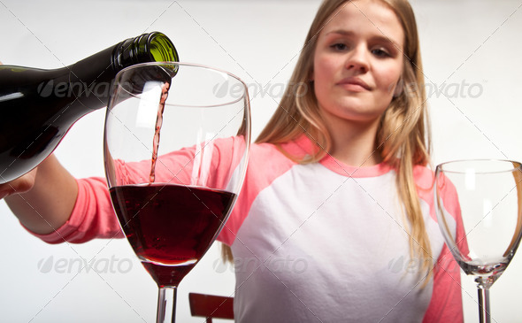 Scandinavian cute young girl pouring her glass with red wine