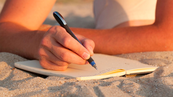 Man Writing In His Diary At The Beach Man Writing In His Diary At The Beach