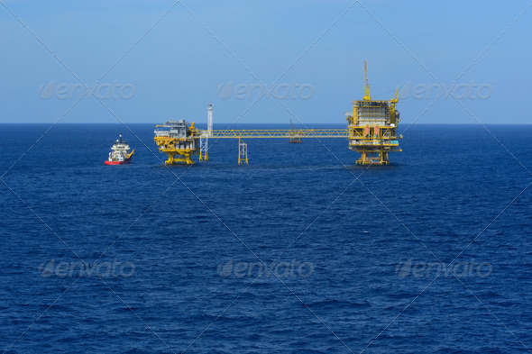 The offshore drilling oil rig and supply boat top view from aircraft.