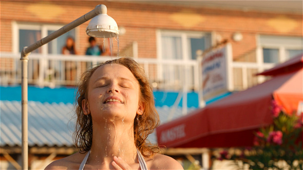 Woman Rinsing Of at the Beach Under a Shower Woman Rinsing Of at the Beach Under a Shower