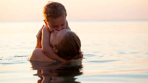 Loving Mother Hugging With Her Son in the Sea Loving Mother Hugging With Her Son in the Sea