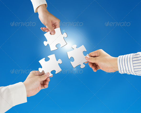 Hands hold puzzles with clear blue sky and sun light