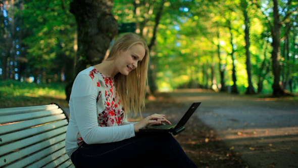 Young Woman Using Her Laptop In the Park Young Woman Using Her Laptop In the Park