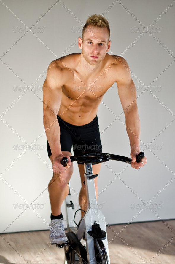 Handsome young man doing spinning on bike - Stock Photo - Images