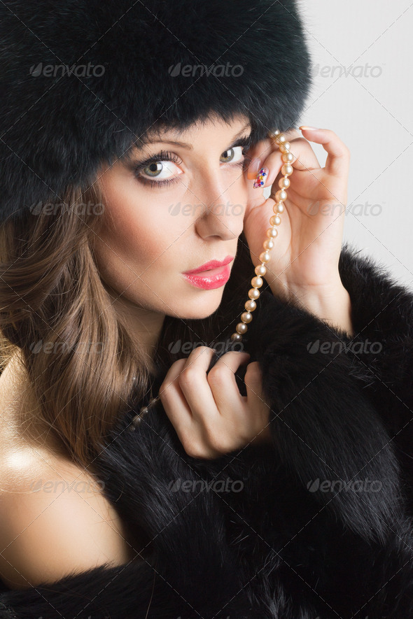 Sensual woman wearing black fur and pearls - Stock Photo - Images