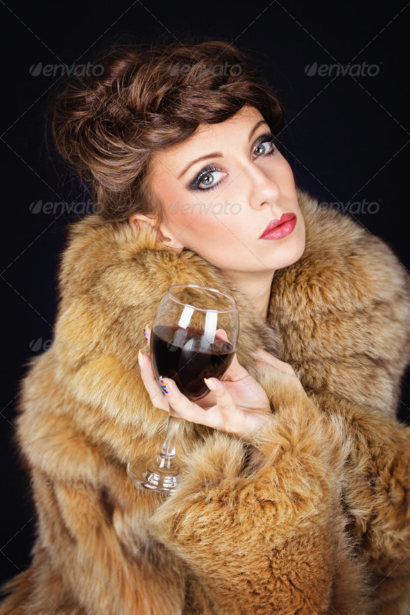 Elegant lady with red wine wearing brown fur coat - Stock Photo - Images