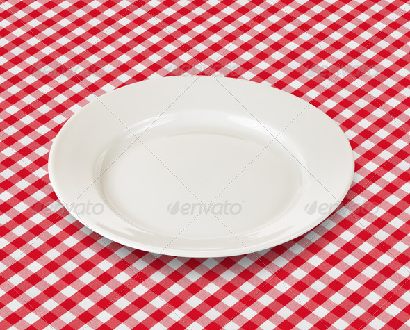white plate over red checked picnic tablecloth