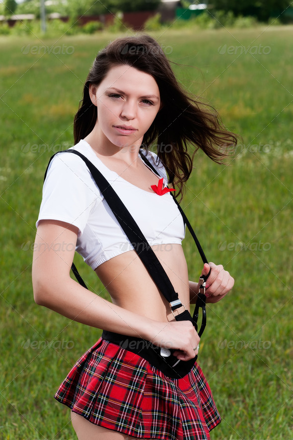 Young pretty woman in white top and red mini skirt at nature background