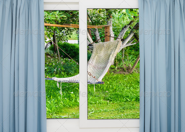 window with curtains overlooking the garden with a hammock