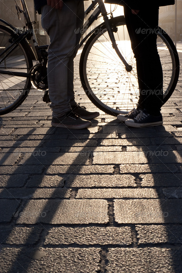 Legs of a young couple face to face with bicycle