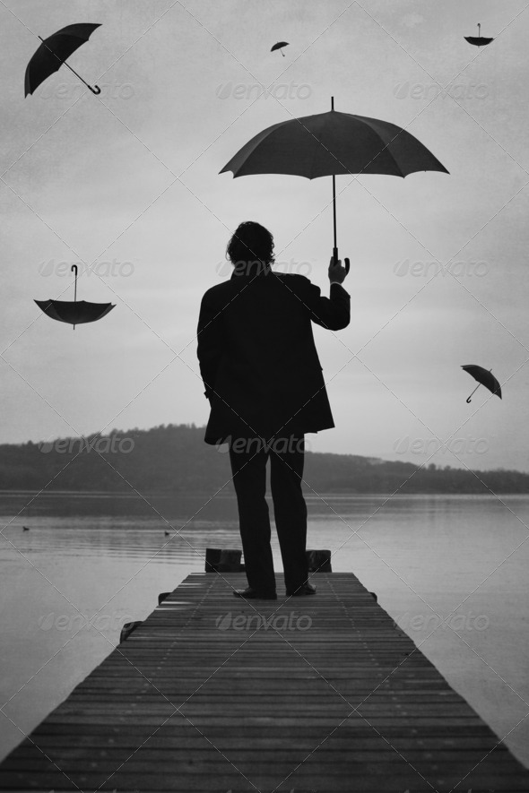 Man looks at sunset sky full of umbrellas