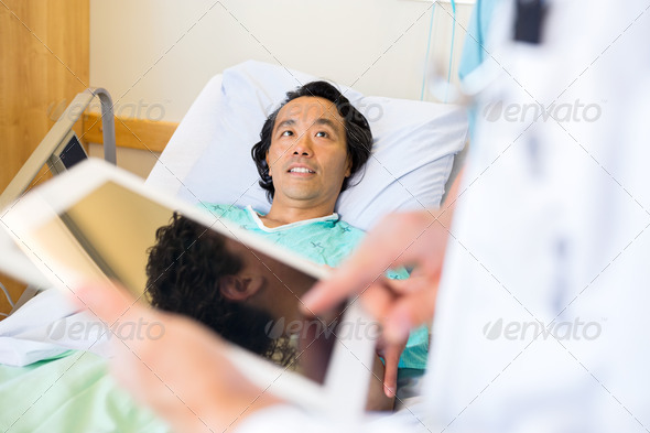 Patient Looking At Doctor Using Digital Tablet