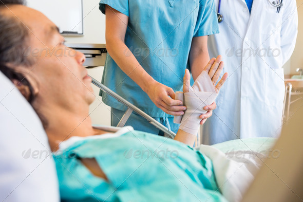 Nurse Putting Bandage On Patient's Hand In Hospital (Misc) Photo Download