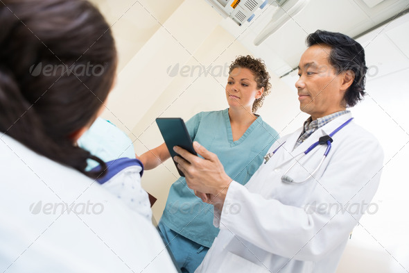 Medical Team With Female Patient In Examination Room (Misc) Photo Download