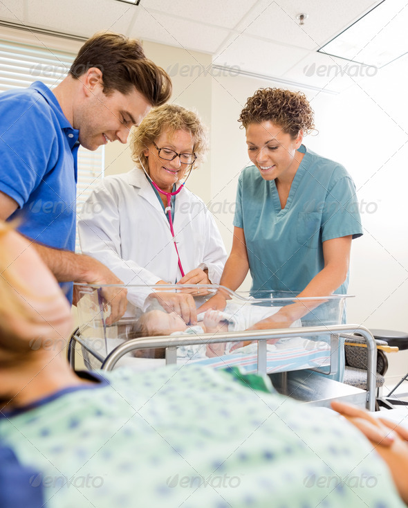 Medical Team Examining Babygirl By Man With Mother In Foreground (Misc) Photo Download