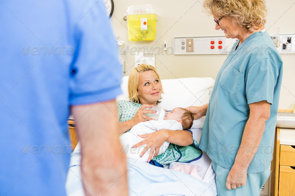 Woman Looking At Nurse While Feeding Milk To Babygirl (Misc) Photo Download