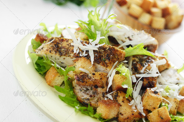 Caesar chicken salad on white table