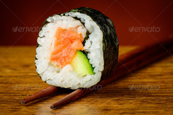 Futomaki sushis roll on chopsticks