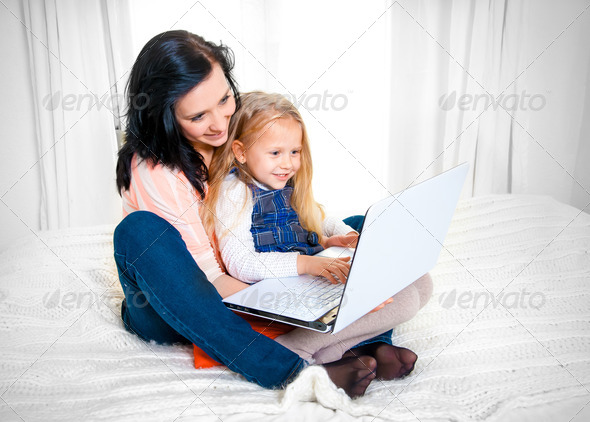 happy mother and daughter working on a laptop