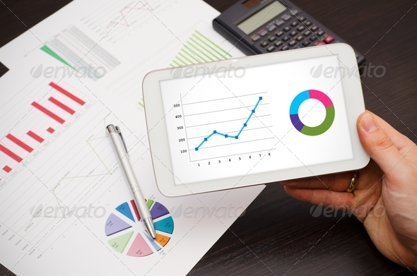 Businessman working with tablet pc. Report charts in background