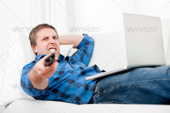 relaxed man using Computer at home switching tv on