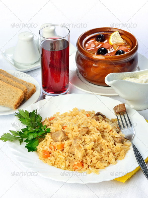 Still life of setout table with soup in ceramic pots, Kiev chicken cutlet and glass of red wine. - Stock Photo - Images