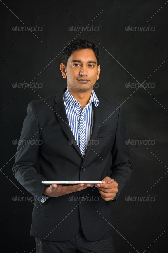 indian business man with tablet on dark background