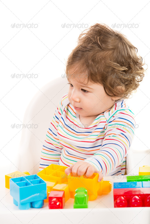 Toddler boy with toys looking away