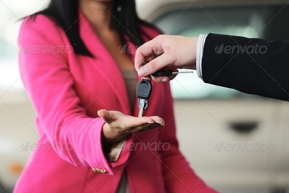 Man handing woman automobile keys for the new car