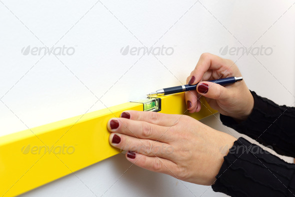 A woman using a spirit level for home work