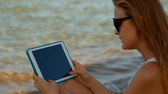 Woman Using Pad By Sea Woman Using Pad By Sea