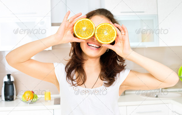 Funny Woman with Orange over Eyes in the Kitchen