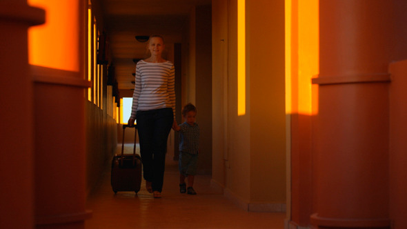 Mother And Son With Luggage in Hotel Corridor Mother And Son With Luggage in Hotel Corridor
