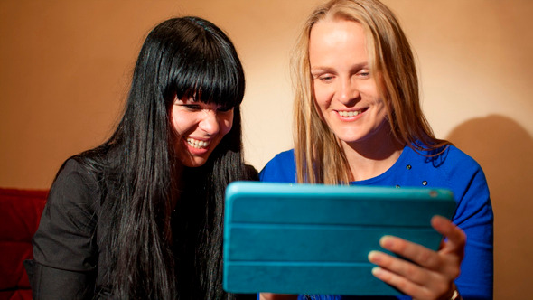 Two Young Woman Reading A Tablet-Pc Two Young Woman Reading A Tablet-Pc