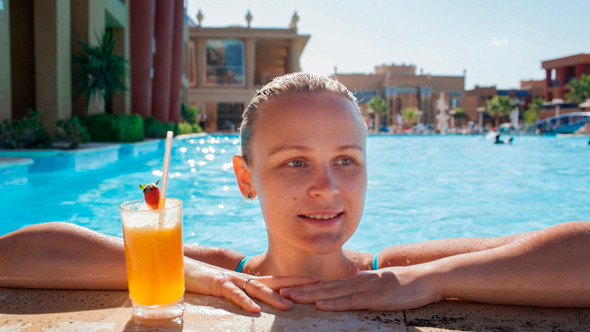 Woman in the Pool with Juice and Splashing Feet Woman in the Pool with Juice and Splashing Feet