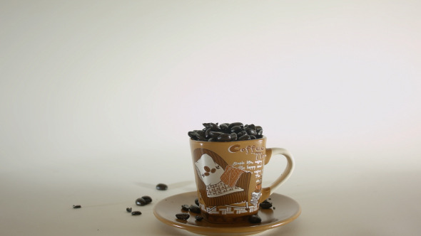 Coffee Beans Poured Into Small Coffee Cup Coffee Beans Poured Into Small Coffee Cup
